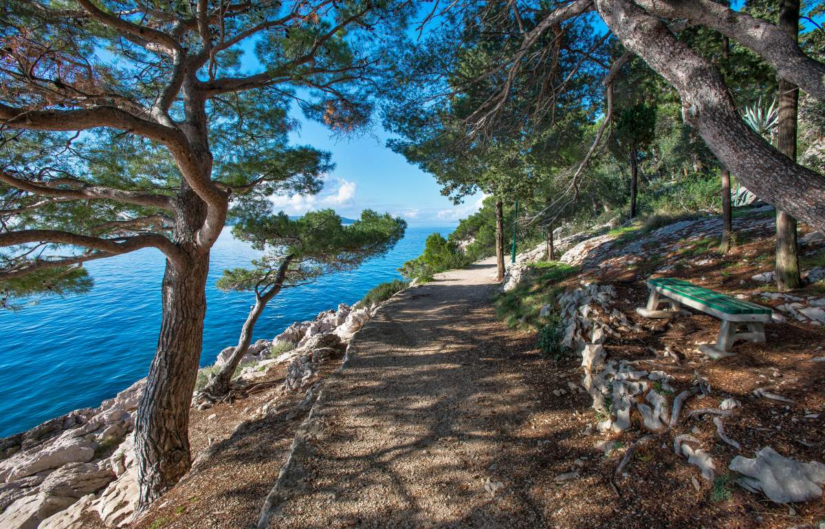 Dirt road on St. Peter's peninsula in Makarska with sea on the left and nature on the right